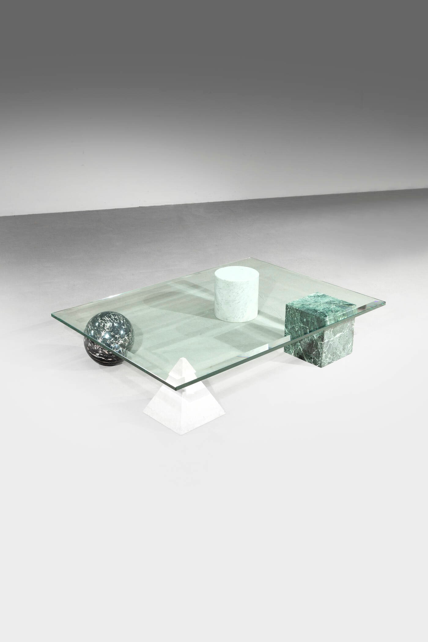 MASSIMO VIGNELLI: MASSIMO VIGNELLI Tavolino mod. Metafora Basi geometriche in marmo colorato e piano in vetro. Prod. Casigliani, 1979 cm 21.5x110x80 Bibl.: Giuliana Gramigna, "Repertorio del Design Italiano