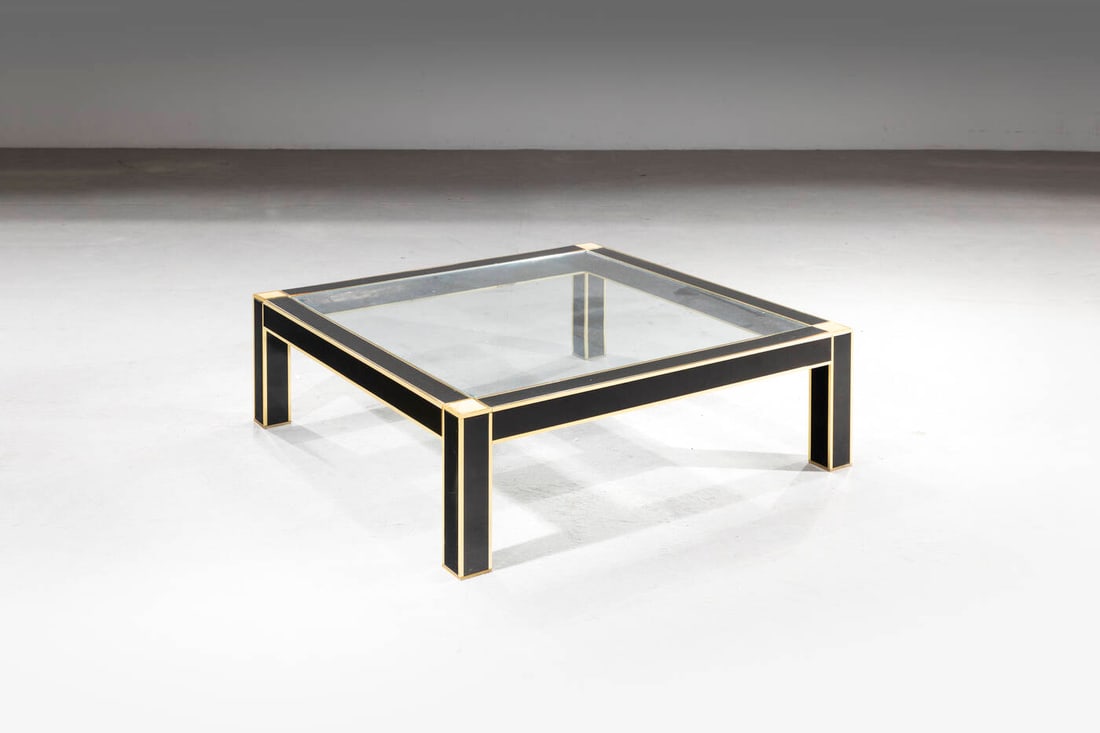 PIERRE CARDIN: PIERRE CARDIN Tavolino Struttura in legno laccato, piano in vetro e particolari in ottone Anni '70 cm 34x110x110 Sbeccature del piano e difetti