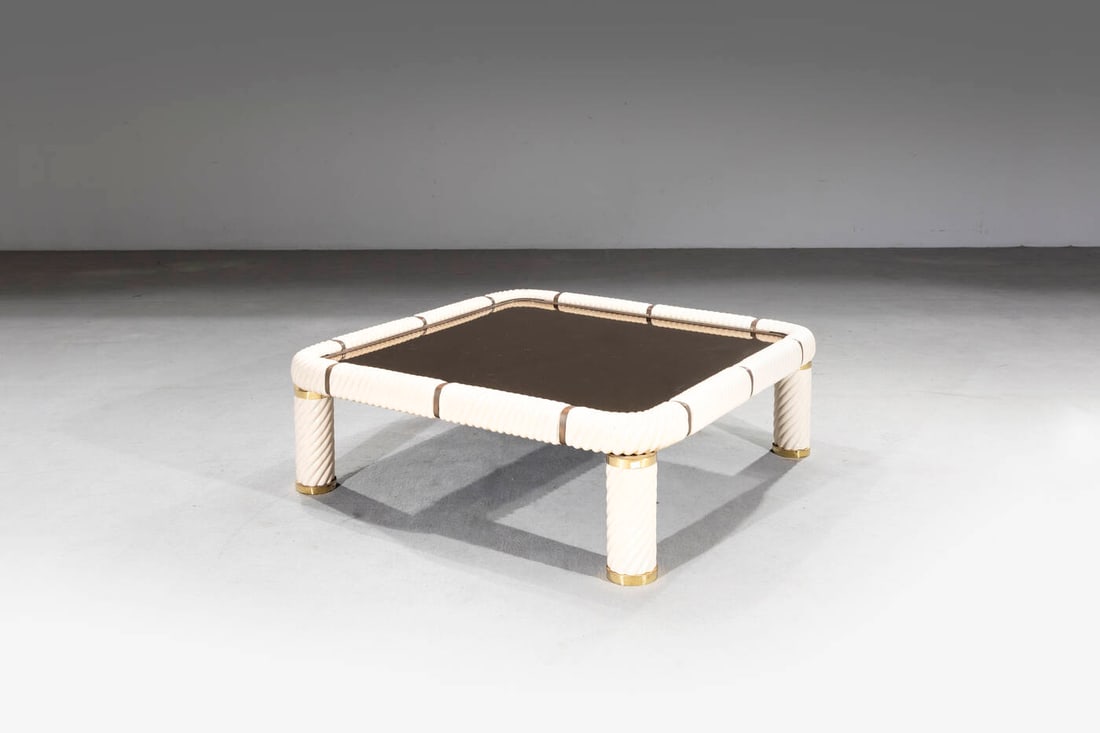 TOMMASO BARBI: TOMMASO BARBI Tavolino Struttura in ceramica bianca e ottone, piano in vetro specchiato. Anni '70 cm 39x115x115 Piccoli difetti