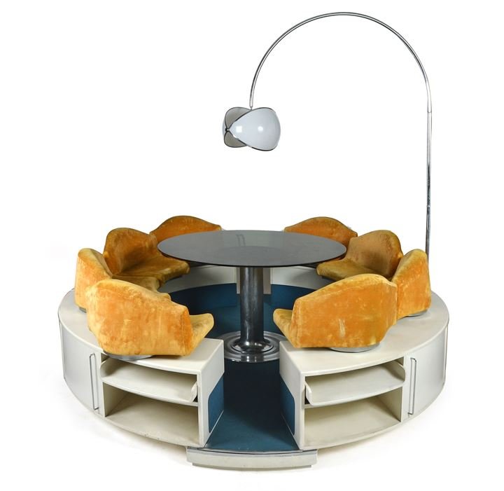 SUPERSTUDIO (attribuito) Sala da pranzo composta da: tavolo centrale in vetro con base in acciaio cromato, struttura in legno laminato e sedute imbottite, piantana a fusto in metallo e perspex Anni 70cm 220x270x280