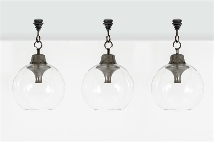 CACCIA DOMINIONI LUIGI_x000D_ Tre lampade a sospensione: Globo in cristallo di Murano soffiato trasparente, trottola in alluminio con gancio in ferro brunito.Prod. Azucena anni '80cm 45x65Bibl.: Catalogo Azucena