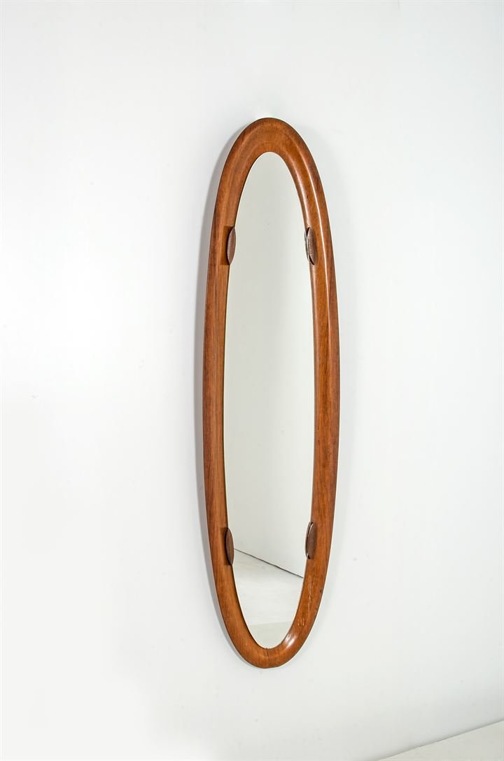 PRODUZIONE ITALIANA: Specchio in legno di teak curvato e vetro specchiato. Anni '60. cm 140x40
