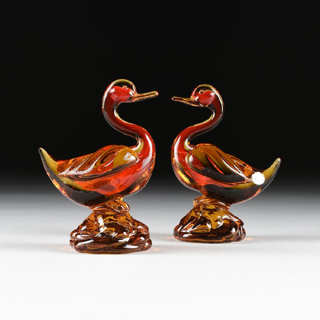A PAIR OF MURANO AMBERINA ART GLASS FIGURES OF SWANS,: A PAIR OF MURANO AMBERINA ART GLASS FIGURES OF SWANS, LATE 20TH CENTURY, the pair in vibrant red-orange amberina glass, with faded silver foil labels. Height: 6 5/8"