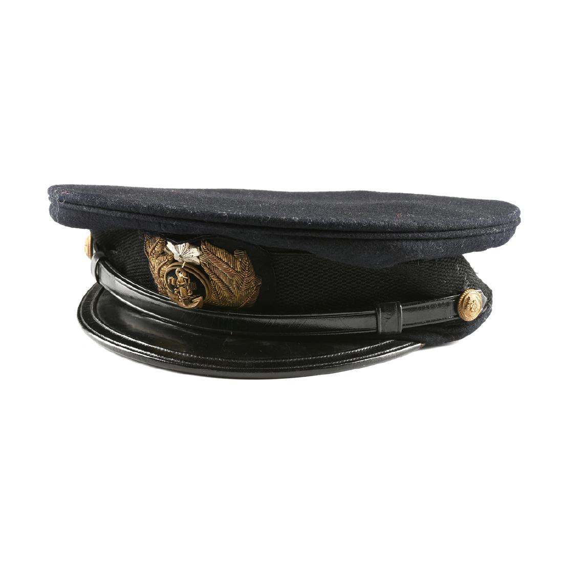 A JAPANESE NAVY WORLD WAR II ERA BLACK FELTED WOOL: A JAPANESE NAVY WORLD WAR II ERA BLACK FELTED WOOL PEAKED CAP, CIRCA 1940-1945, with braided black band and black leather visor, with couched gold, gilt metal and silvered metal Officer's emblem, purp