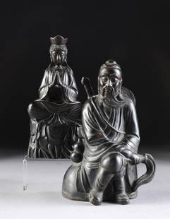 TWO CHINESE CARVED HARDWOOD FIGURES OF IMMORTALS, 20TH: TWO CHINESE CARVED HARDWOOD FIGURES OF IMMORTALS, 20TH CENTURY, comprising a seated figure of Guanyin wearing long flowing robes and hands in prayer position above covered crossed legs with a serene