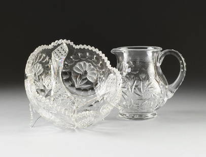 TWO ANGLO AMERICAN CUT CRYSTAL WARES, MODERN,: TWO ANGLO AMERICAN CUT CRYSTAL WARES, MODERN, the water pitcher with bombé form sides centering stylized cut decoration beneath a short neck and flaring rim with everted spout opposite a circular