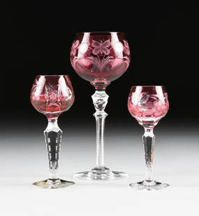 A GROUP OF THREE AMERICAN AND CONTINENTAL RUBY CUT TO: A GROUP OF THREE AMERICAN AND CONTINENTAL RUBY CUT TO CLEAR WINE STEMS, CIRCA 1900-1960, comprising an Imperlux, East German cordial glass, the teardrop form bowl cut twith grape leaf and fruit