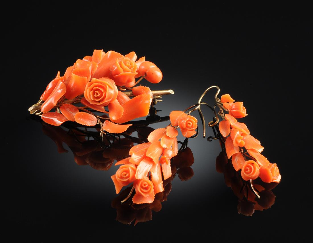 PINK CORAL FLORAL LADY'S BROOCH WITH EARRINGS,: PINK CORAL FLORAL LADY'S BROOCH WITH EARRINGS, in gold setting consisting of an elaborate floral brooch measuring 58 x 41 mm, in custom box with pierced wire earrings with an 18 x 30 mm floral drop. N