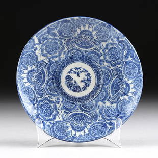 A SMALL BLUE AND WHITE CERAMIC PLATE,: A SMALL BLUE AND WHITE CERAMIC PLATE, centering a triangle rimmed circle surrounded by stylized lotus designs, reversing to a pale blue underside and unglazed short rimmed foot. Diameter: 9"