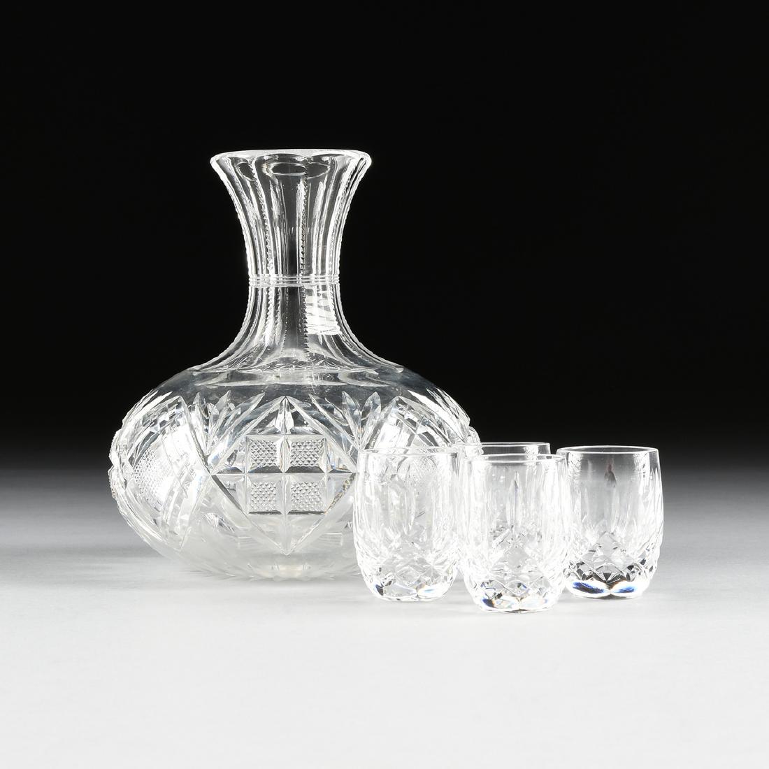 A BRILLIANT CUT CRYSTAL CARAFE TOGETHER WITH FOUR: A BRILLIANT CUT CRYSTAL CARAFE TOGETHER WITH FOUR WATERFORD CUT CRYSTAL SHOT GLASSES IN THE "LISMORE" PATTERN, the carafe with panel cut banded neck with edge cuts over fan and diamond fields of straw