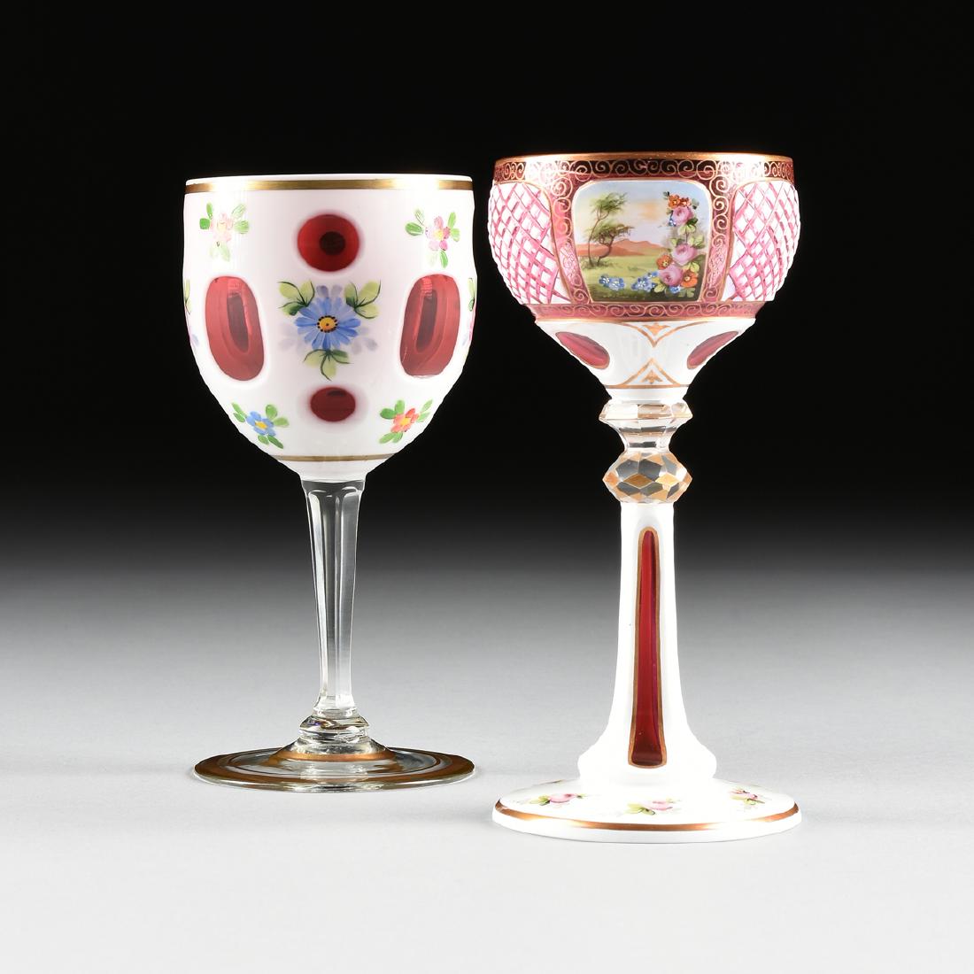 A GROUP OF TWO WHITE GLASS CUT TO CRANBERRY GLASSES,: A GROUP OF TWO WHITE GLASS CUT TO CRANBERRY GLASSES, comprising a Johann Oertel & Co. wine goblet in white glass cut to cranberry with ocular slice cuts at the top and bottom of the bowl centering a b