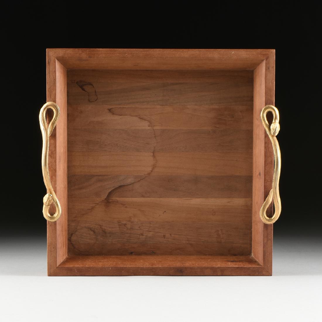 A MODERN GILT METAL MOUNTED VARIOUS WOODS TRAY,: A MODERN GILT METAL MOUNTED VARIOUS WOODS TRAY, of square form with a carved teak flat rim and everted border, mounted with serpent form sinuous handles, on a various woods banded base. Height: 3.50" 