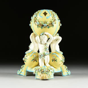 A CONTINENTAL TURQUOISE BLUE AND YELLOW GROUND ENAMELED: A CONTINENTAL TURQUOISE BLUE AND YELLOW GROUND ENAMELED MAJOLICA TULIP VASE, POSSIBLY FRENCH, CIRCA 1900, with three putti on bent knees draped in encrusted flowering vines and holding aloft a