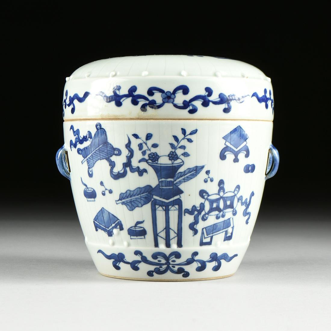 A CHINESE CANTON BLUE AND WHITE PORCELAIN COVERED JAR,: A CHINESE CANTON BLUE AND WHITE PORCELAIN COVERED JAR, QING DYNASTY (1644-1912), of garden seat or drum form with incised lines and applied porcelain bosses suggesting a tufted seat, the lid centering