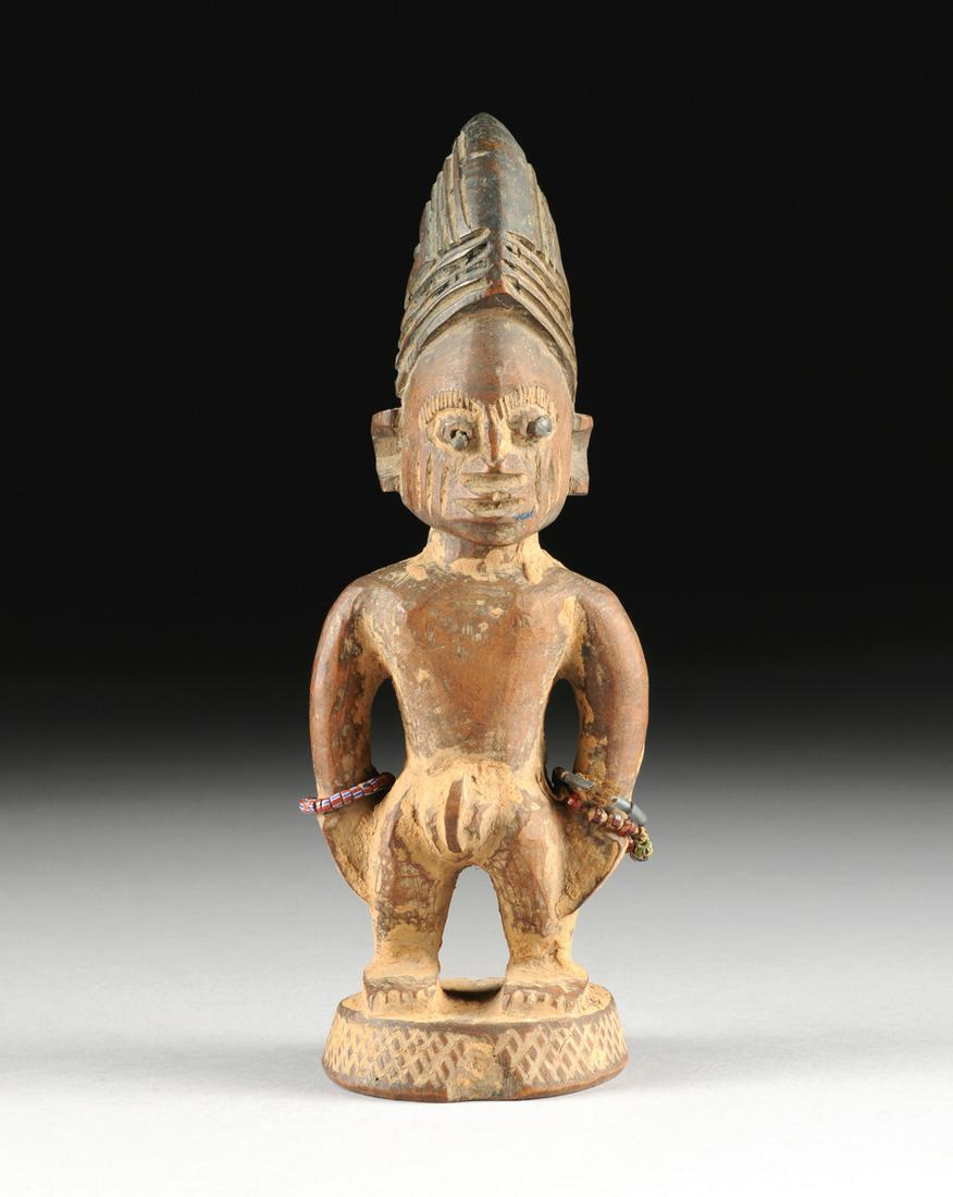 A YORUBA CARVED WOOD MALE TWIN IBEJI FIGURE, NIGERIA,: A YORUBA CARVED WOOD MALE TWIN IBEJI FIGURE, NIGERIA, LATE 19TH/EARLY 20TH CENTURY, modeled in a standing position with bulging eyes centering iron nail head decoration beneath incised eyelash details