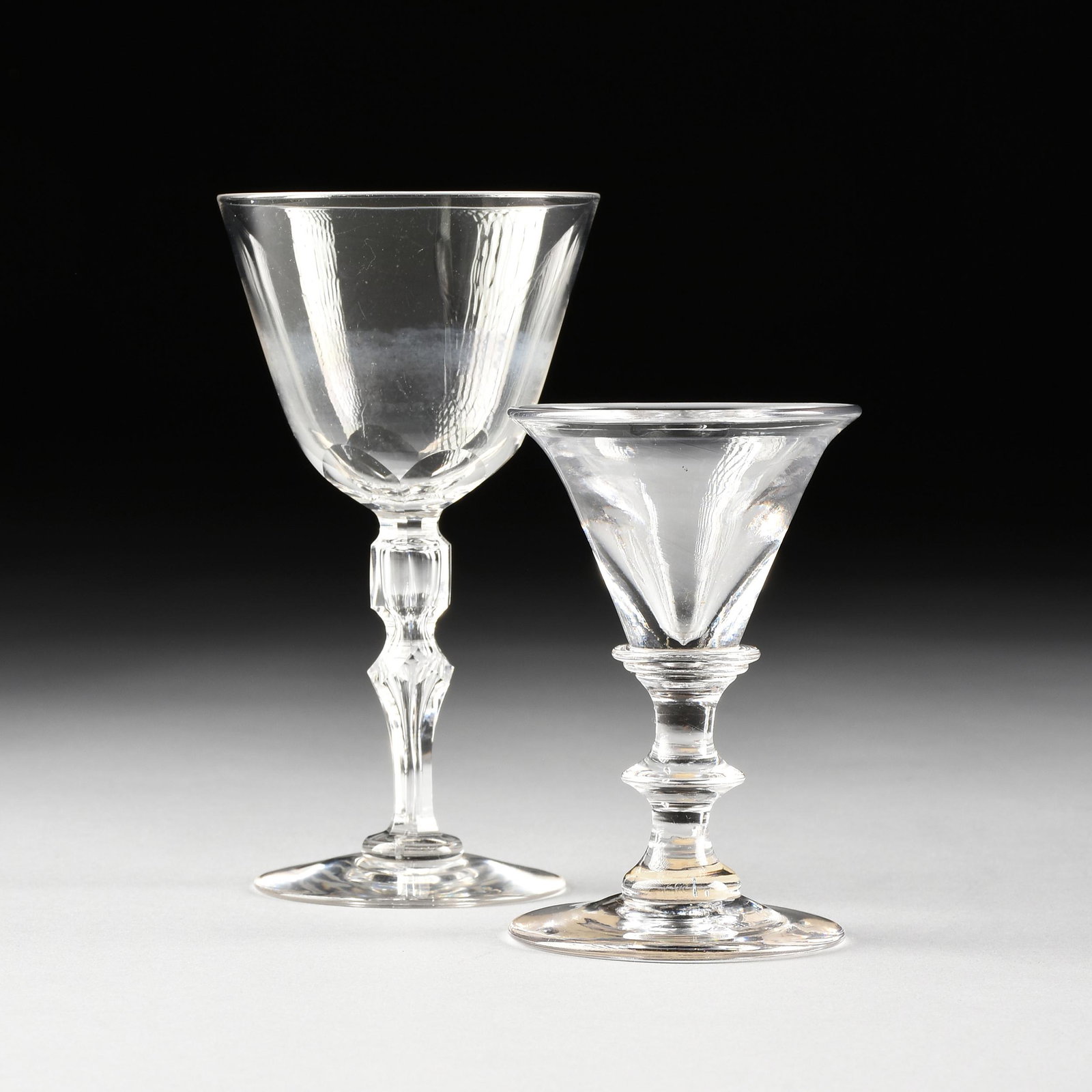 A GEORGE III PERIOD CLEAR CRYSTAL DECEPTIVE TOASTING: A GEORGE III PERIOD CLEAR CRYSTAL DECEPTIVE TOASTING GLASS, ENGLISH, CIRCA 1800, the bell form bowl with thickened walls, raised on angular knopped stem with spreading foot, with printed label of the 