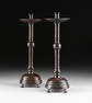 A PAIR OF TALL MEDIEVAL STYLE PATINATED BRONZE CANDLE