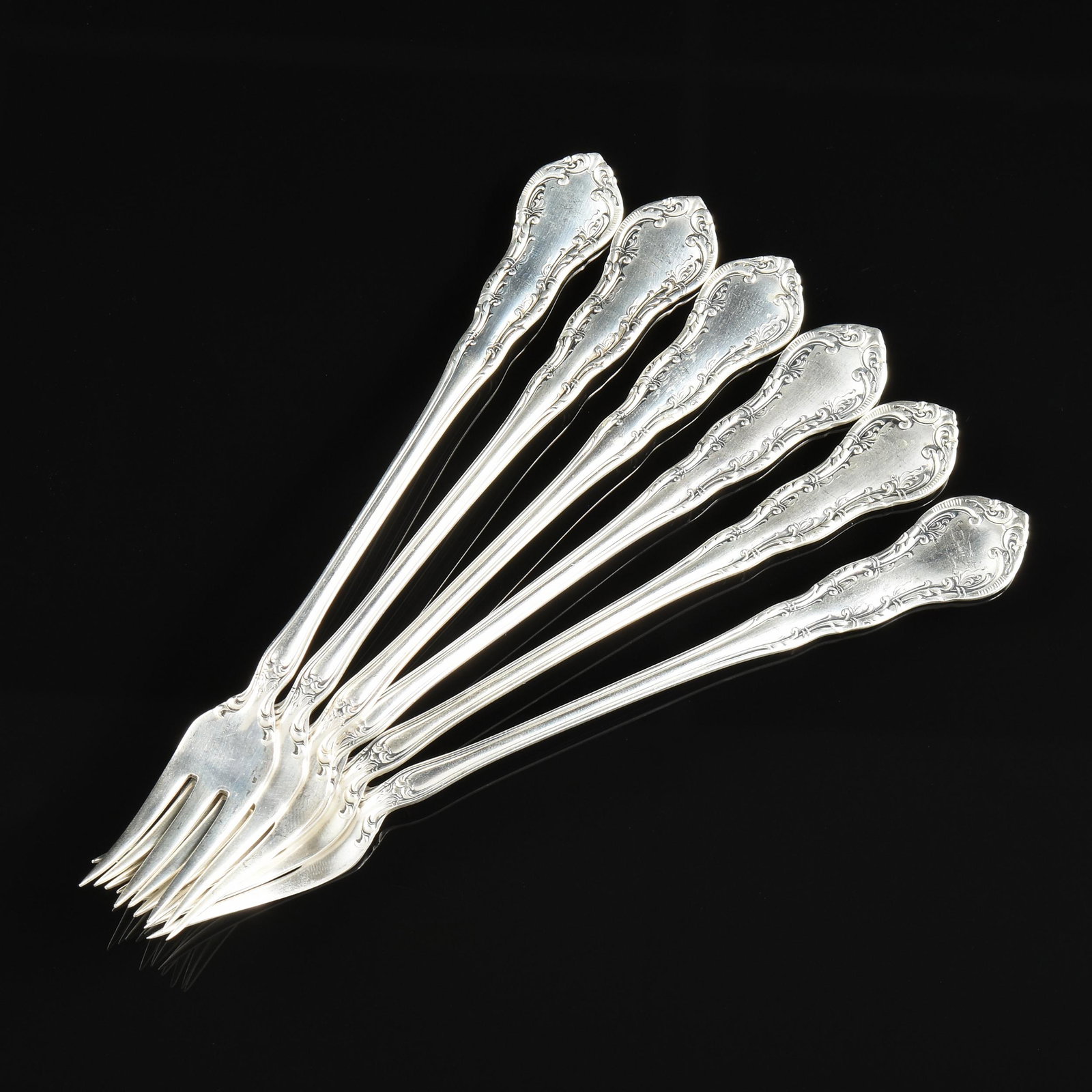 A SET OF TWELVE AMERICAN STERLING SILVER OYSTER FORKS,: A SET OF TWELVE AMERICAN STERLING SILVER OYSTER FORKS, WALLACE, IRVING, the pattern introduced in 1900, each handle has winding vines and whiplash tendrils in the Art Nouveau taste, to splayed tripar