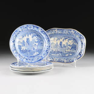 AN ASSEMBLED GROUP OF SIX STAFFORDSHIRE BLUE AND WHITE: AN ASSEMBLED GROUP OF SIX STAFFORDSHIRE BLUE AND WHITE TRANSFER PRINT POTTERY LUNCHEON PLATES AND A SMALL SERVING PLATTER IN A VARIATION OF "THE VILLAGE CHURCH" PATTERN, ENGLAND, CIRCA 1830-1840,