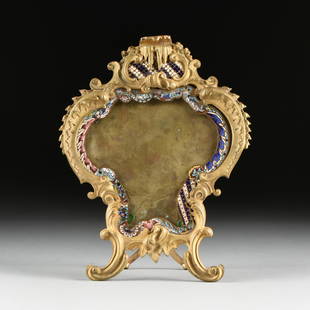 A FRENCH ROCOCO REVIVAL ORMOLU AND CHAMPLEVÉ ENAMEL: A FRENCH ROCOCO REVIVAL ORMOLU AND CHAMPLEVÉ ENAMEL FRAME, LATE 19TH CENTURY, of stylized heart form and with a dripping grottoesque "C" scrolls cartouche crest, enclosing a blue and white striped qu