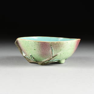 A CHINESE FAMILLE ROSE PEACH FORM GLAZED PORCELAIN: A CHINESE FAMILLE ROSE PEACH FORM GLAZED PORCELAIN BRUSH WASHER BOWL, 20TH CENTURY, in the form of a bisected peach resting on a leafy stem with exterior covered in a light green glaze with splotches