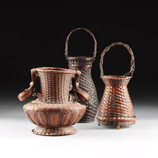 A GROUP OF THREE JAPANESE WOVEN BAMBOO BASKETS,: A GROUP OF THREE JAPANESE WOVEN BAMBOO BASKETS, one of conical form beneath a tightly woven flaring neck and braided flat rim and loop handle raised on cut bamboo block feet, height: 14 3/8";