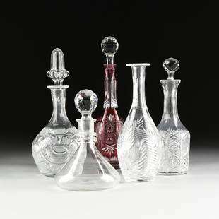 AN ASSEMBLED GROUP OF FIVE ANGLO AMERICAN AND GERMAN: AN ASSEMBLED GROUP OF FIVE ANGLO AMERICAN AND GERMAN CUT CRYSTAL DECANTERS, 20TH CENTURY, comprising a cranberry red cut to clear Nachtmann bottle form decanter with sides of stylized double pinwheels