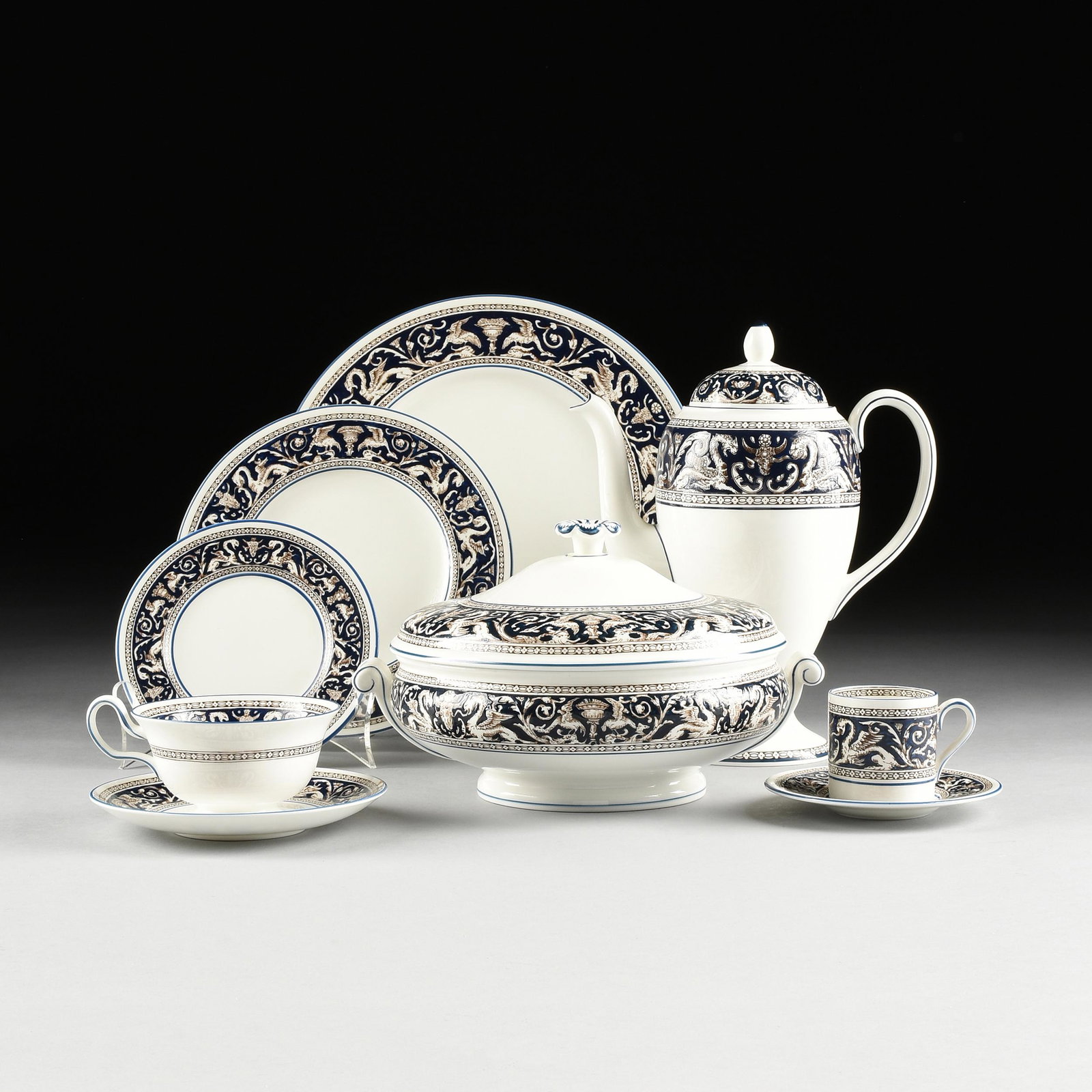 A THIRTY-EIGHT PIECE WEDGWOOD BONE CHINA "FLORENTINE": A THIRTY-EIGHT PIECE WEDGWOOD BONE CHINA "FLORENTINE" PART DINNER SERVICE, MARKED, ENGLAND, LATE 20TH CENTURY, with traditional details on a dark blue ground and comprising six dinner plates, nine sal