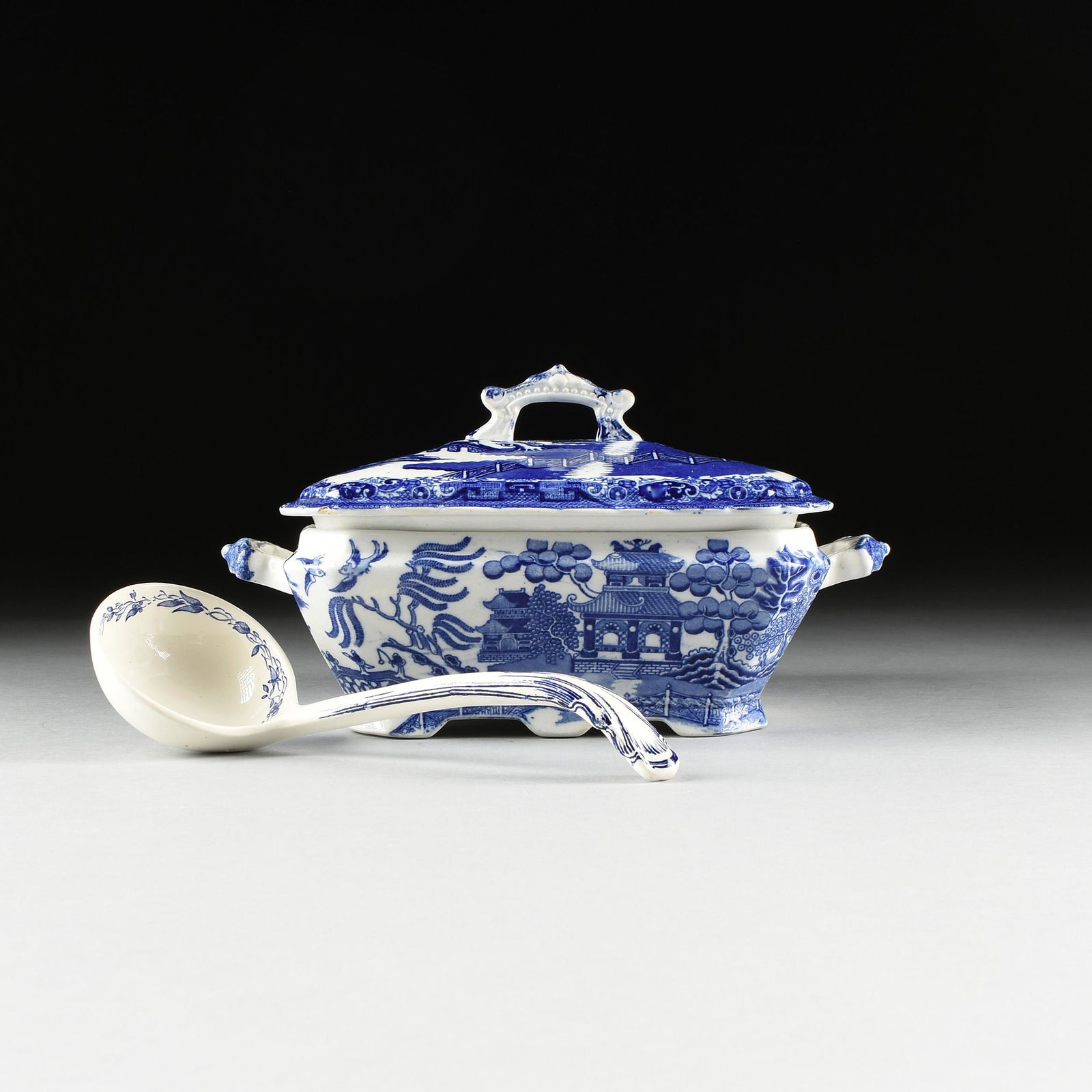 AN ENGLISH STAFFORDSHIRE BLUE WILLOW SQUARE PAGODA: AN ENGLISH STAFFORDSHIRE BLUE WILLOW SQUARE PAGODA HANDLED TUREEN WITH LADLE, TUNSTALL, 1881-1910, by William Adams & Co., the handles are unusually modeled as pagoda forms, the square beveled lid wit