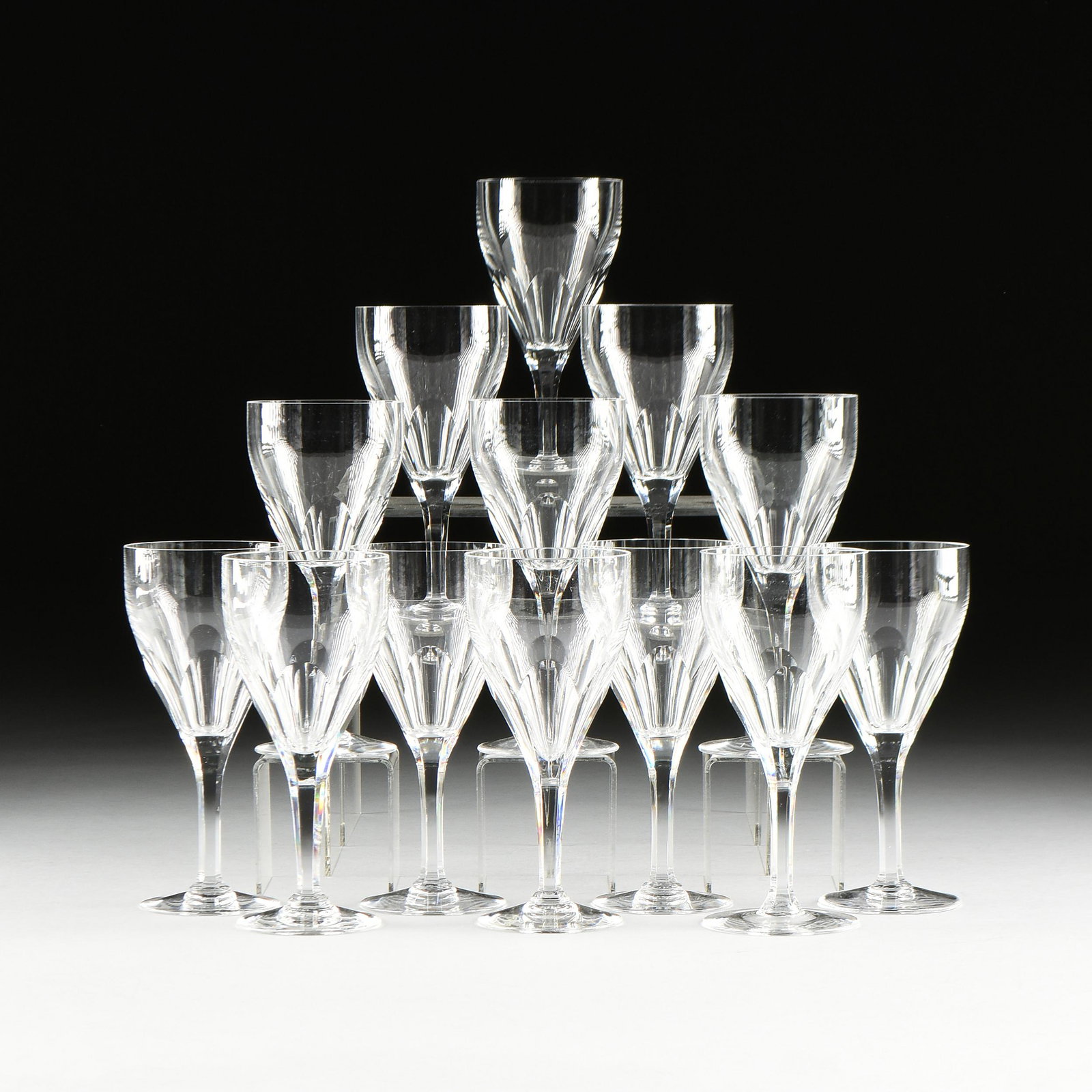 AN ASSEMBLED SET OF TWELVE VAL ST. LAMBERT "GEVAERT": AN ASSEMBLED SET OF TWELVE VAL ST. LAMBERT "GEVAERT" CLEAR CRYSTAL WINE STEMS, BELGIAN, MID/LATE 20TH CENTURY, petal decoration taper to circular feet, most marked in monogram "VSL," and two marked "V