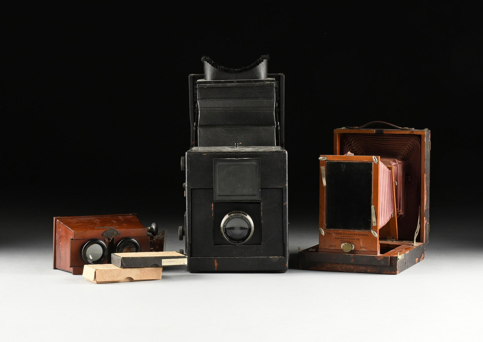 A GROUP OF THREE EARLY PHOTOGRAPHY STEREOSCOPE AND CAMERAS, PARIS AND ROCHESTER, CIRCA 1900,: A GROUP OF THREE EARLY PHOTOGRAPHY STEREOSCOPE AND CAMERAS, PARIS AND ROCHESTER, CIRCA 1900, comprising a French "Unis France Stereoscope," mahogany, painted metal, and plastic, of sarcophagus form, w