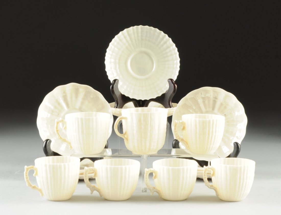 A BELLEEK EGG SHELL PORCELAIN PARTIAL TEA SERVICE,: A BELLEEK EGG SHELL PORCELAIN PARTIAL TEA SERVICE, IRELAND, SECOND AND THIRD PERIODS, CIRCA 1891-1946, in shell molded motif, comprised of seven tea cups having yellow lustre glaze to scrolling coral 