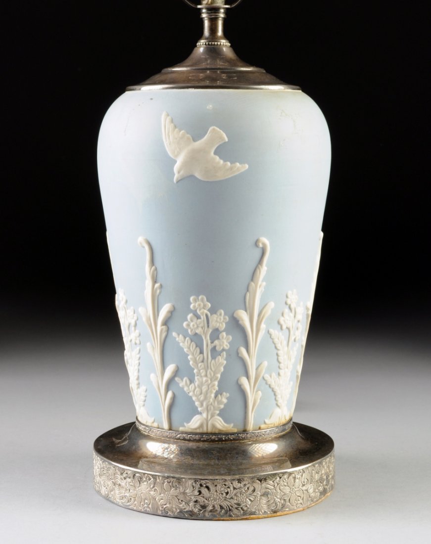 A BLUE AND WHITE JASPERWARE BISQUE PORCELAIN TABLE LAMP: A BLUE AND WHITE JASPERWARE BISQUE PORCELAIN TABLE LAMP WITH SILVER PLATED MOUNTS, EARLY-MID 20TH CENTURY, the sides molded in relief with birds and vinery, raised on silver plated base with a foliate
