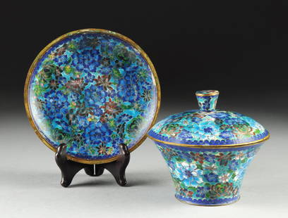 A CHINESE BLUE GROUND CLOISONNÉ COVERED DISH AND: A CHINESE BLUE GROUND CLOISONNÉ COVERED DISH AND UNDERPLATE, LATE 20TH CENTURY, each piece polychrome enameled throughout with "1,000 Blossoms" decoration and comprising; a flaring circular bowl