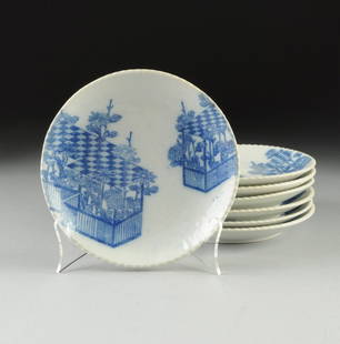 SEVEN JAPANESE BLUE AND WHITE SHIRO-IGE PLATES, 20TH: SEVEN JAPANESE BLUE AND WHITE SHIRO-IGE PLATES, 20TH CENTURY, each plate with notched edge rim, transfer blue and white scene of a fenced garden with tiled roof, impressed mark to underside. 