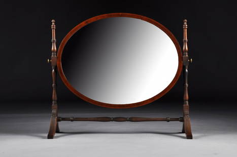 A FEDERAL BOXWOOD STRING INLAID MAHOGANY DRESSING: A FEDERAL BOXWOOD STRING INLAID MAHOGANY DRESSING MIRROR, EARLY 19TH CENTURY, the oval beveled mirror within a flat conforming framed on two turned supports, raised on splayed legs joined by a turned