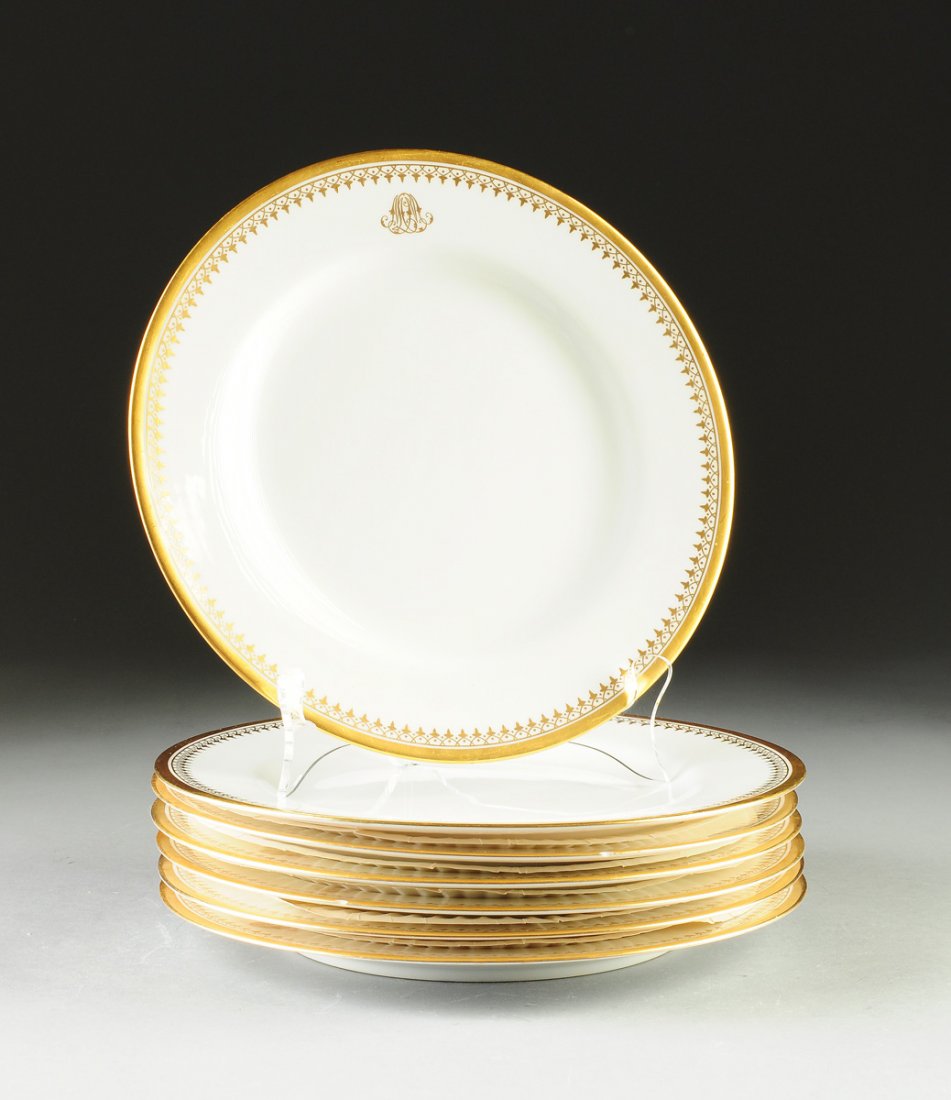 A SET OF SEVEN SPODE PARCEL GILT WHITE GROUND DINNER: A SET OF SEVEN SPODE PARCEL GILT WHITE GROUND DINNER PLATES, GREEN PRINTED SPODE LABEL, RETAILED BY T. GOODE & CO., LONDON, EARLY 20TH CENTURY, each with a broad gilt rim enclosing a band of interlock