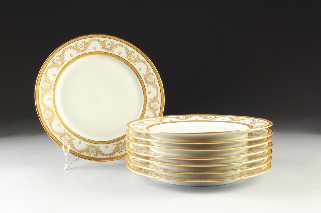 A SET OF EIGHT LIMOGES PARCEL GILT SERVICE PLATES,: A SET OF EIGHT LIMOGES PARCEL GILT SERVICE PLATES, GREEN MAKER'S MARKS, RETAILED BY WILLIAM GUERIN & CO, EARLY 20TH CENTURY, each with a heavily gilt and chased rim of octagonal links centering a bord