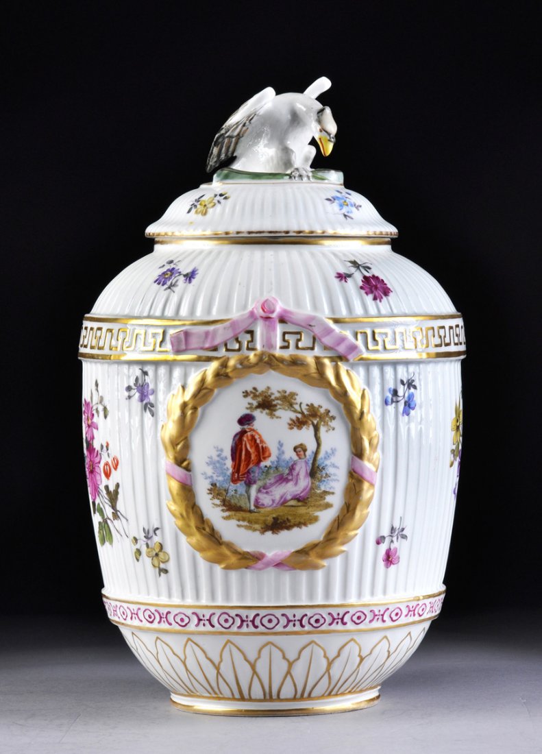 A NEOCLASSICAL STYLE GERMAN PARCEL GILT AND POLYCHROME: A NEOCLASSICAL STYLE GERMAN PARCEL GILT AND POLYCHROME PAINTED PORCELAIN LIDDED URN, POSSIBLY DRESDEN, LATE 19TH/EARLY 20TH CENTURY, of fluted ovoid form with sides centering molded ribbon tied laurel