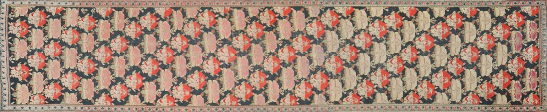 AN ARMENIAN CAUCASIAN RUNNER,: AN ARMENIAN CAUCASIAN RUNNER, the midnight black field worked with staggering rows of stylized flower heads within a central border. 3.7 x 16.7