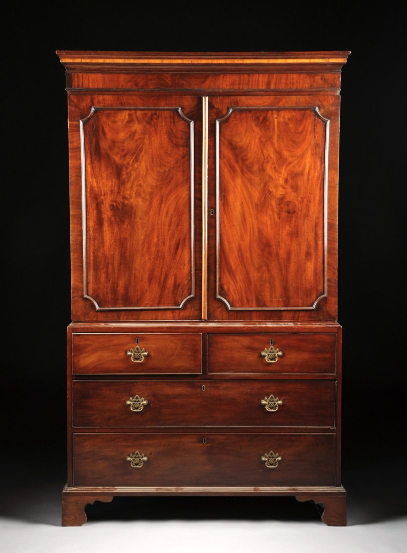 AN ANTIQUE ENGLISH MAHOGANY LINEN PRESS,: AN ANTIQUE ENGLISH MAHOGANY LINEN PRESS, the molded cornice above a pair of long doors opening to a shelved interior above two short drawers and two long drawers and raised on bracket feet. Height: 75
