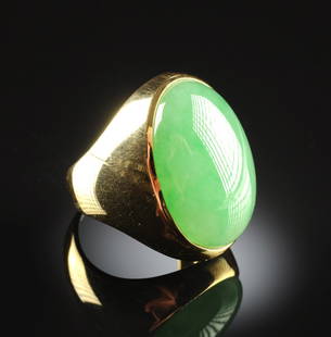 AN 18K YELLOW GOLD AND CHINESE "A" JADEITE JADE GENT'S: AN 18K YELLOW GOLD AND CHINESE "A" JADEITE JADE GENT'S RING, the mounting centering a natural type "A" green jadeite jade oval measuring approximately 17.9 x 25.0 x 8.6 millimeters, fine green color,