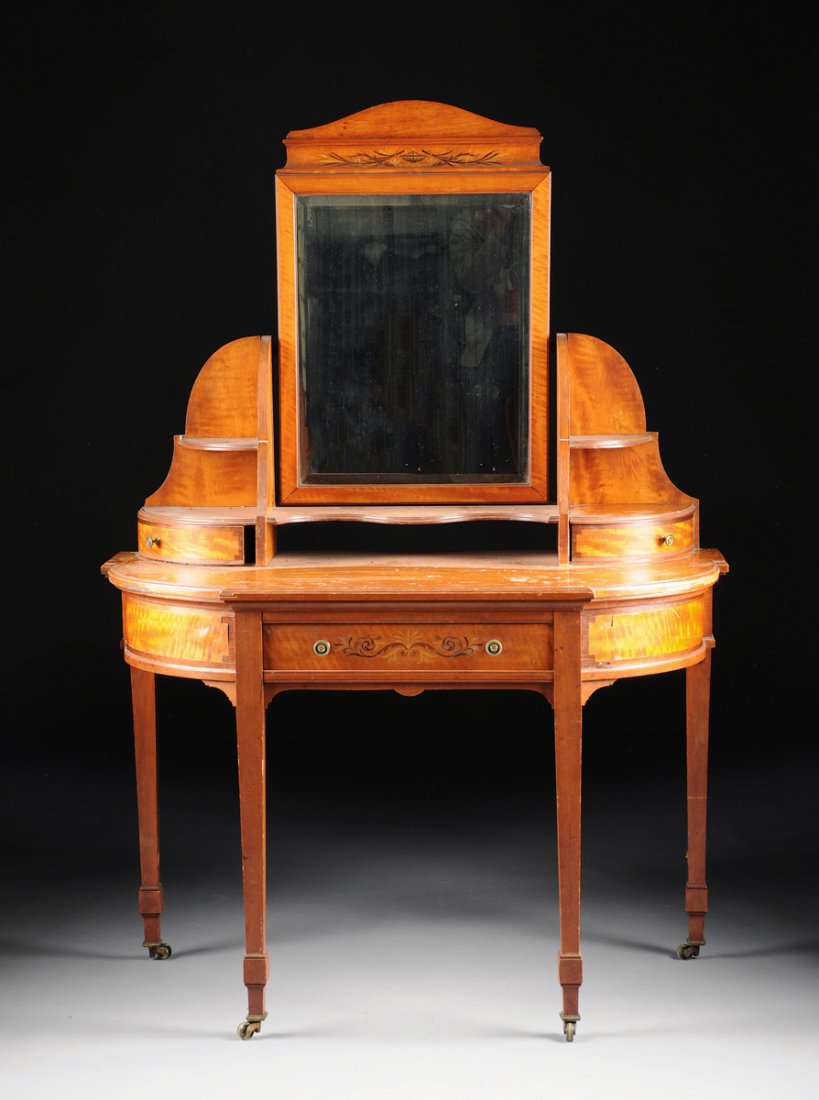 A SHERATON SATINWOOD DRESSING TABLE BY GILLOWS OF: A SHERATON SATINWOOD DRESSING TABLE BY GILLOWS OF LANCASTER, CIRCA 1800, the shaped demilune form centering a beveled rectangular mirror with arched crest above a cavetto inlaid with a classical urn f