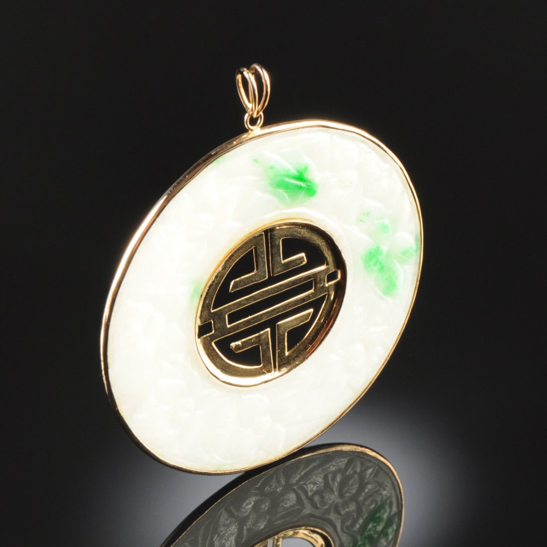 A 14K GOLD AND MOSS IN SNOW CHINESE "A" JADEITE JADE: A 14K GOLD AND MOSS IN SNOW CHINESE "A" JADEITE JADE LADY'S PENDANT, in yellow gold frame, a "moss in snow" disc with yellow gold "shou" center. natural, type 'A' jadeite jade disc is approximately 59