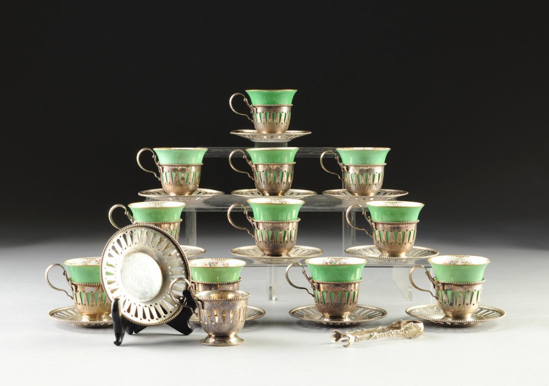 A SET OF TWELVE STERLING SILVER DEMITASSE CUP HOLDERS: A SET OF TWELVE STERLING SILVER DEMITASSE CUP HOLDERS AND SAUCERS TOGETHER WITH A PAIR OF STERLING SUGAR TONGS, AMERICAN, CIRCA 1887-1903, the sterling cup holders and saucers made by the Mauser Manuf