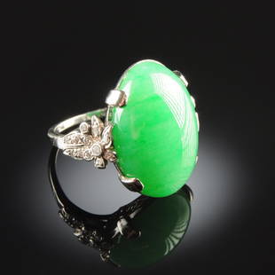 A PLATINUM, CHINESE 'A' JADEITE JADE, AND DIAMOND: A PLATINUM, CHINESE 'A' JADEITE JADE, AND DIAMOND LADY'S RING, in a platinum setting with natural, type 'A' jadeite jade oval cabochon measuring approximately 13.6 x 19.1 x 8.7 millimeters, fine green