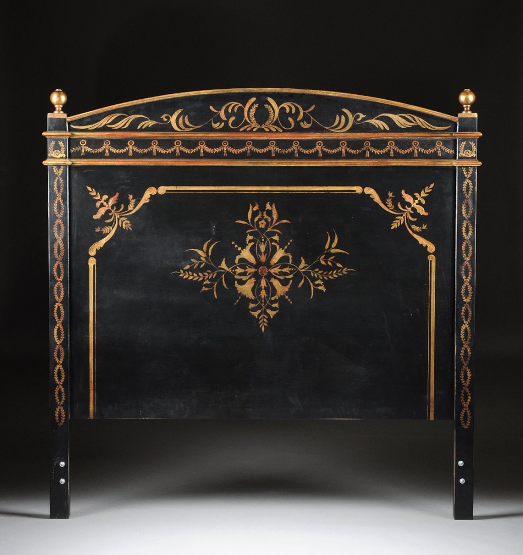 A REGENCY STYLE PARCEL GILT AND BLACK PAINTED WOOD: A REGENCY STYLE PARCEL GILT AND BLACK PAINTED WOOD HEADBOARD, MODERN, with arched crestrail centering a laurel wreath flanked by scrolling foliage above a frieze of discs suspending foliate swags, fla