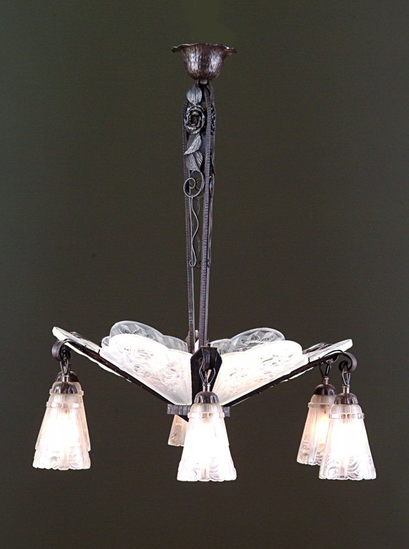 A FRENCH ART DECO PERIOD HAMMERED IRON AND MOLDED GLASS: A FRENCH ART DECO PERIOD HAMMERED IRON AND MOLDED GLASS CHANDELIER, the frosted glass geometrically designed center shaded surrounded by four pendant shades designed by Muller Frères, and signed Mull