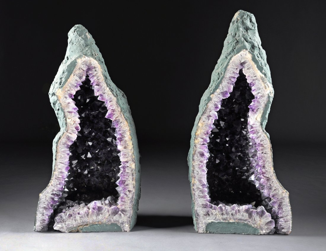 A PAIR OF LARGE AMETHYST GEODES, AMETISTA DO SUL,: A PAIR OF LARGE AMETHYST GEODES, AMETISTA DO SUL, BRAZIL. each center split from one large geode and of vertical pyramidal form revealing natural amethyst crystals in various shades of purple. Height: