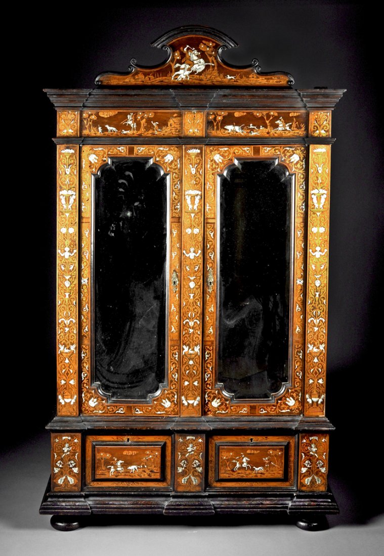 A NORTHERN ITALIAN FRUITWOOD INLAID MIRRORED: A NORTHERN ITALIAN IVORY AND FRUITWOOD INLAID MIRRORED ARMOIRE, LATE 18TH CENTURY, the arched and "C" scroll carved cornice above a scene depicting a man on horseback fending off attacking beasts set 
